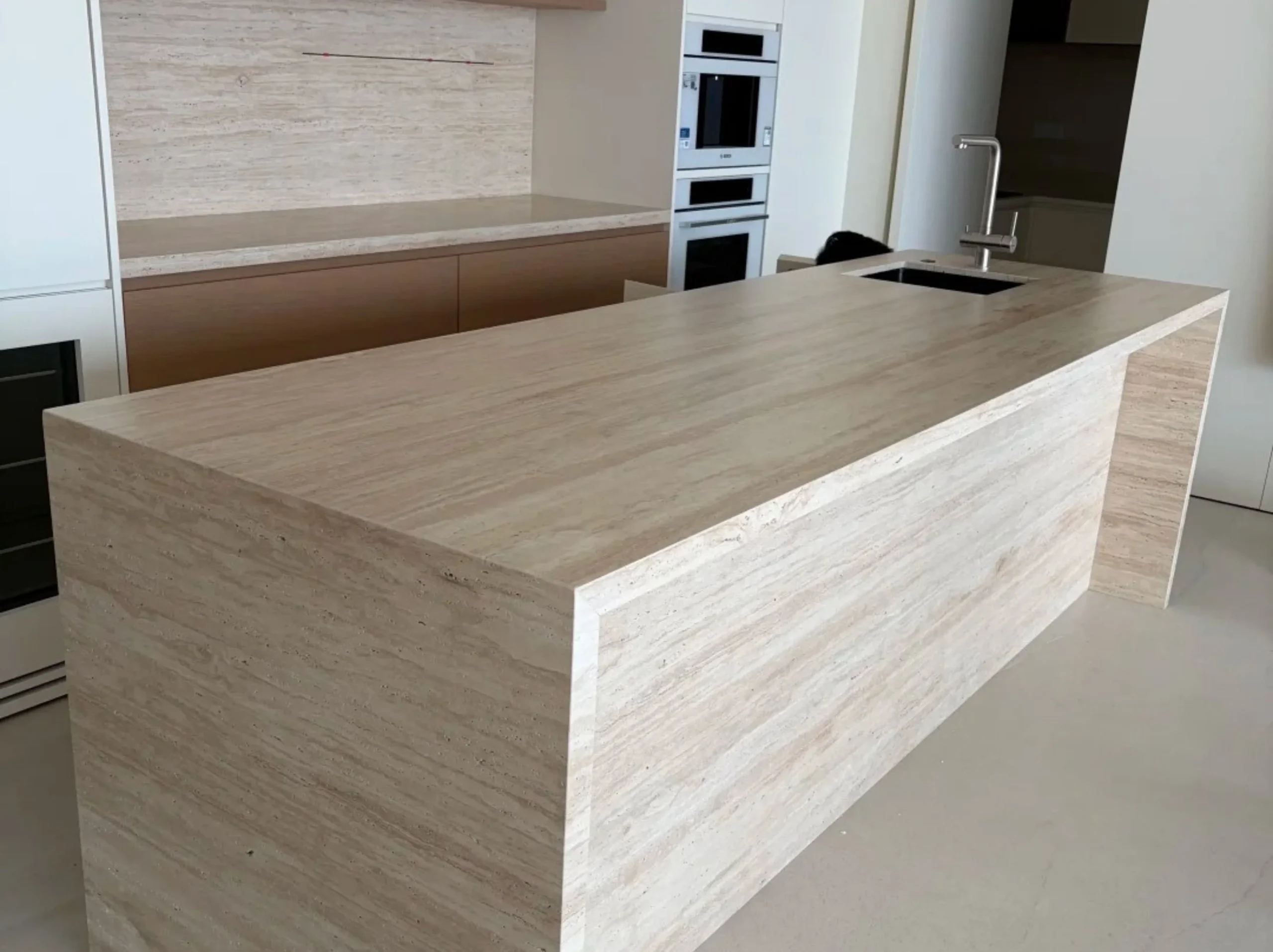 afghan-travertine-wrapped-kitchen-island.webp Fully wrapped Afghan Travertine kitchen island with linear beige veining