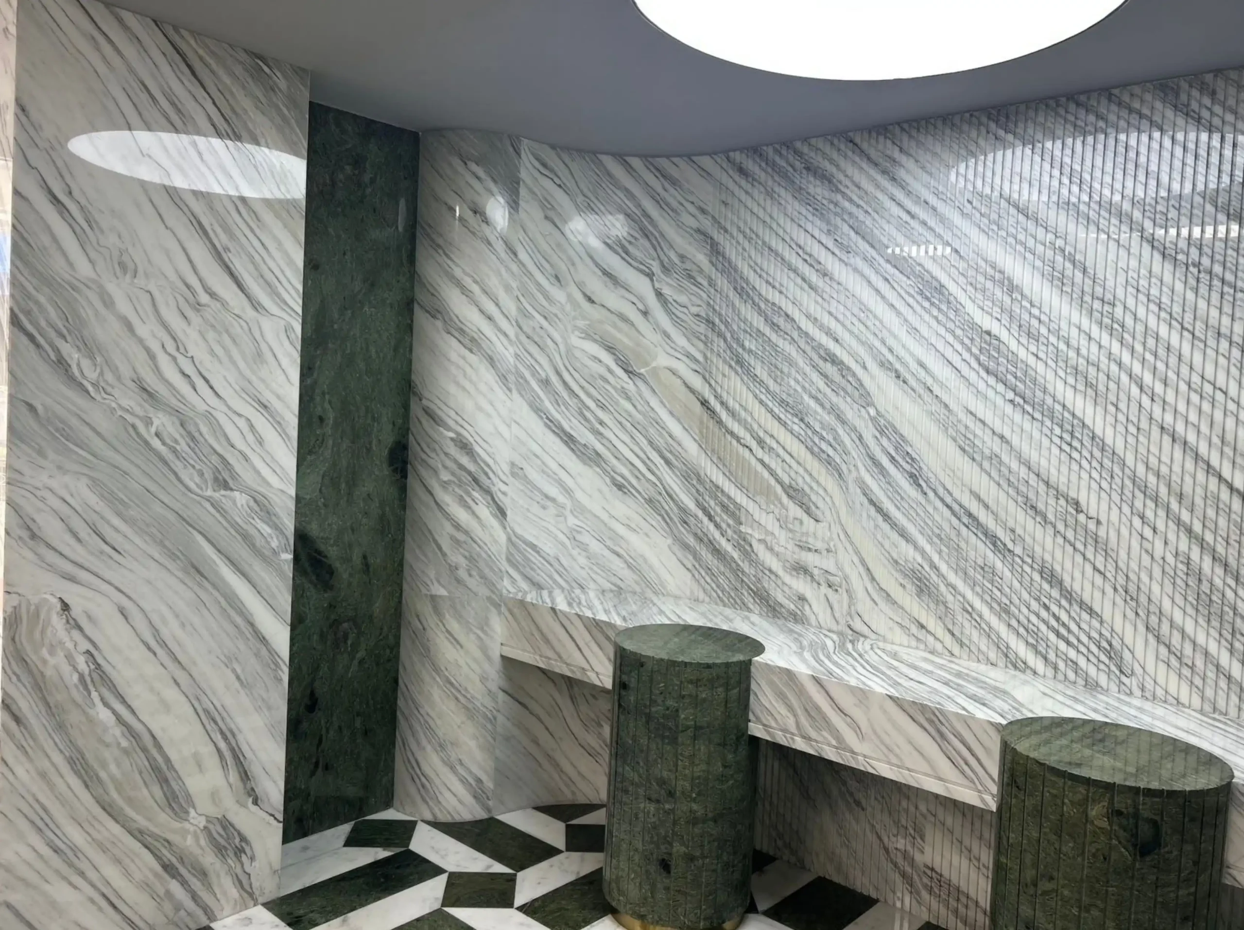 bianco-ondulato-marble-luxury-commercial-interior.webp Bianco Ondulato Marble wall cladding and geometric flooring in a luxury commercial display space