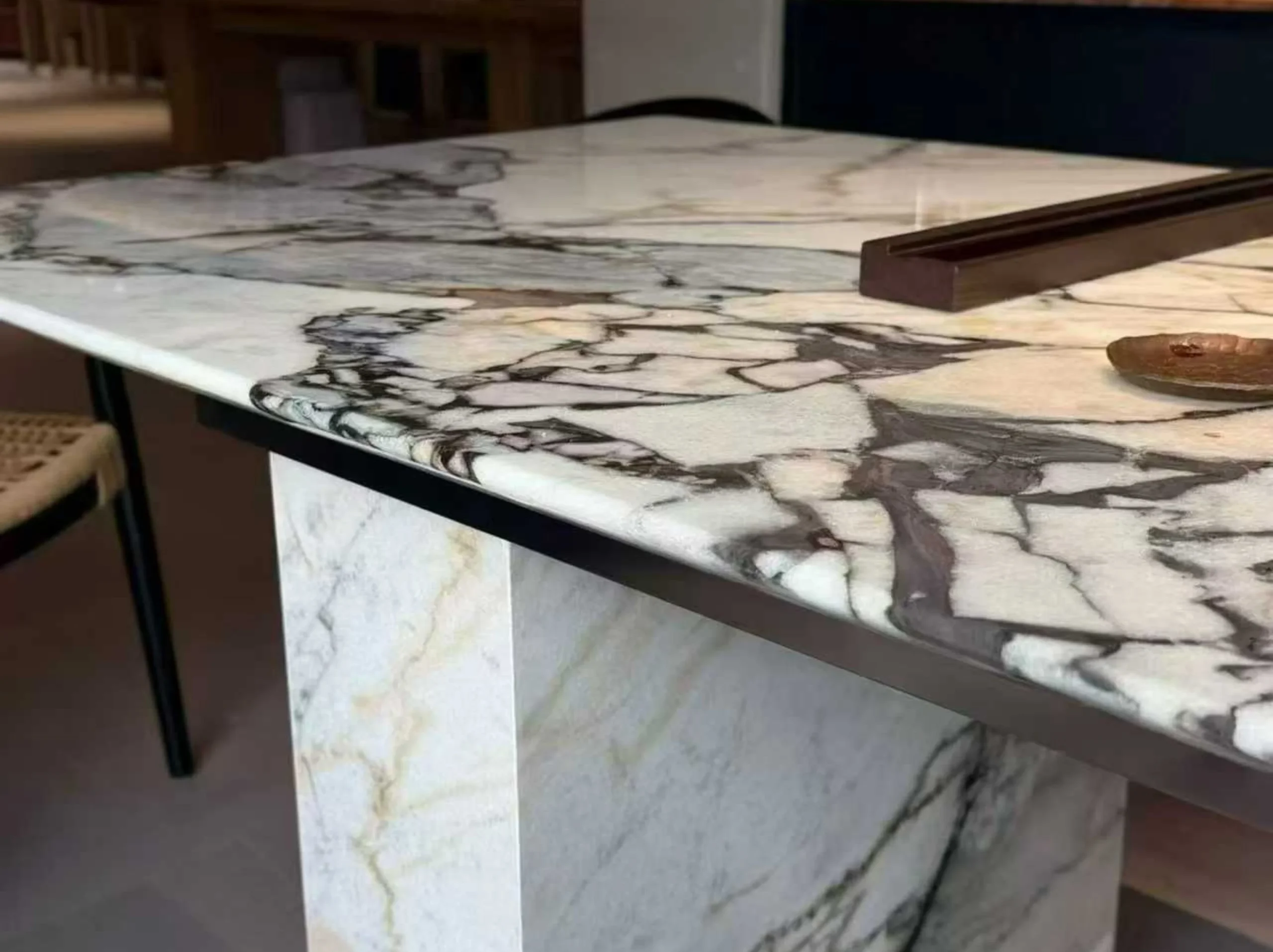 elephant-white-marble-tabletop-edge-detail-01.webp elephant white marble tabletop edge detail with ivory beige grey fragments and dark brecciated pattern