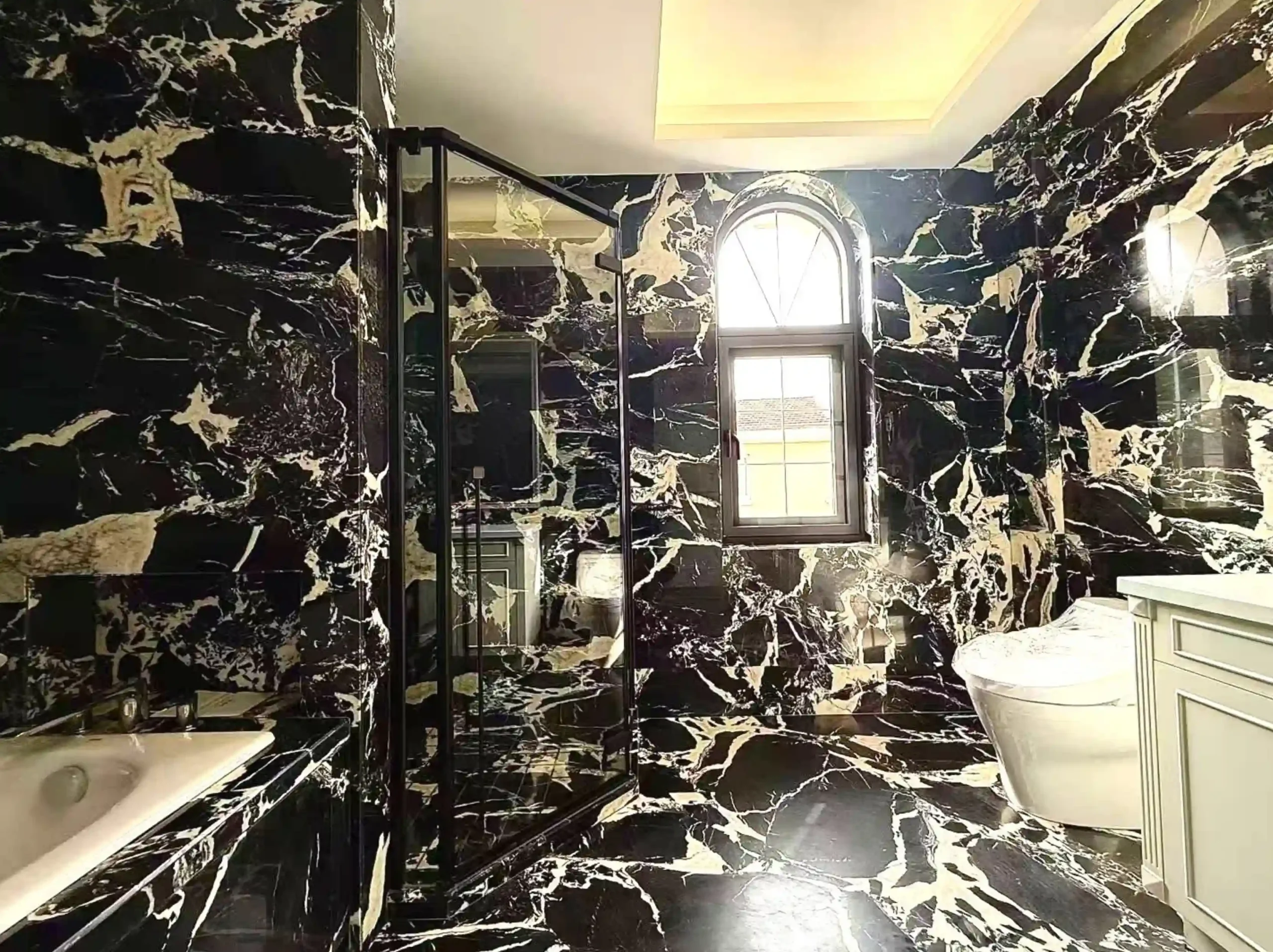 nepoleon-black-marble-bathroom-wall-floor-03.webp nepoleon black marble bathroom wall and floor with bold ivory white breccia veins