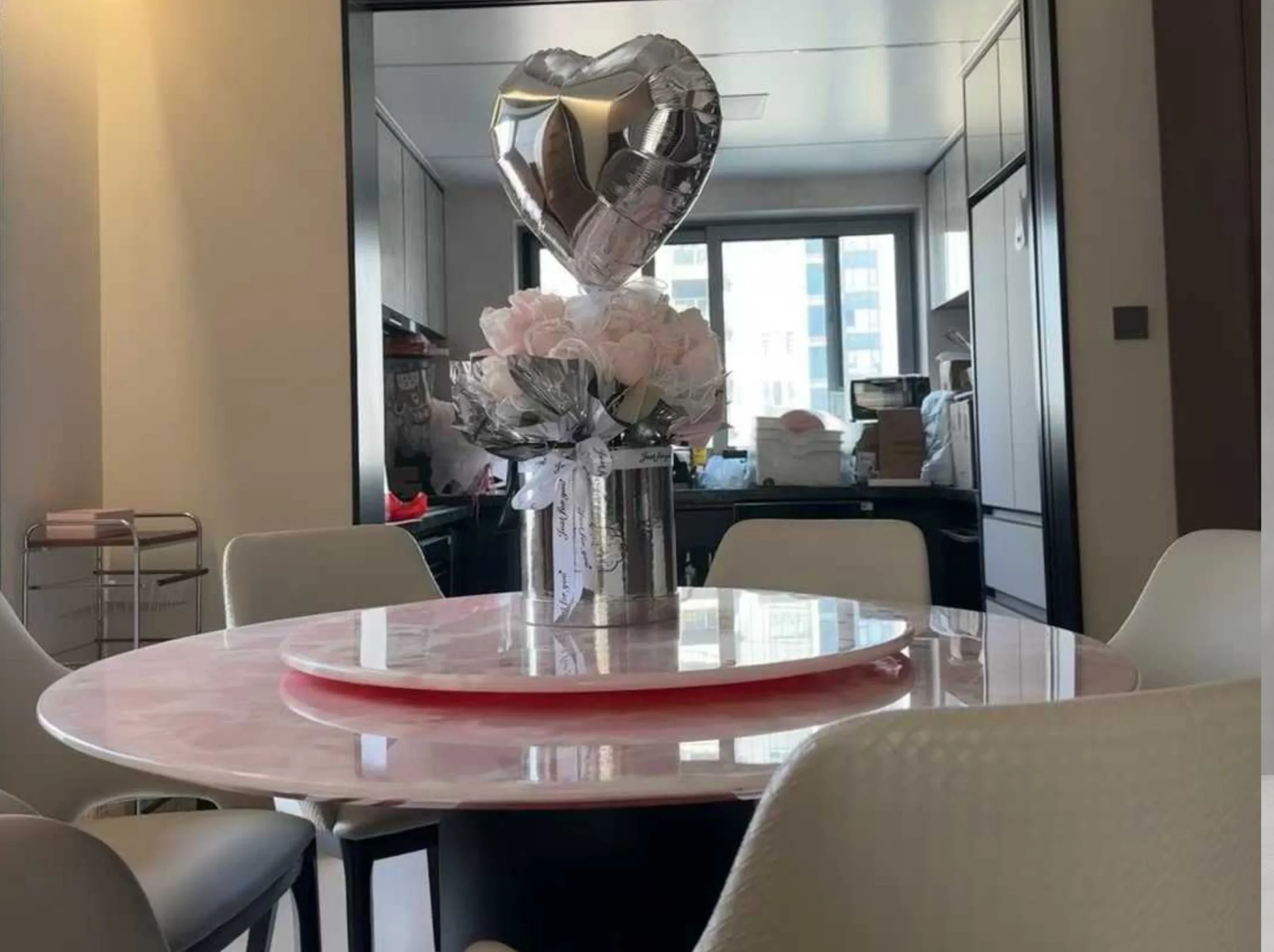 pink-onyx-round-dining-table-residential-interior-01.webp Round Pink Onyx dining table with a polished stone top and matching rotating tray in a modern residence