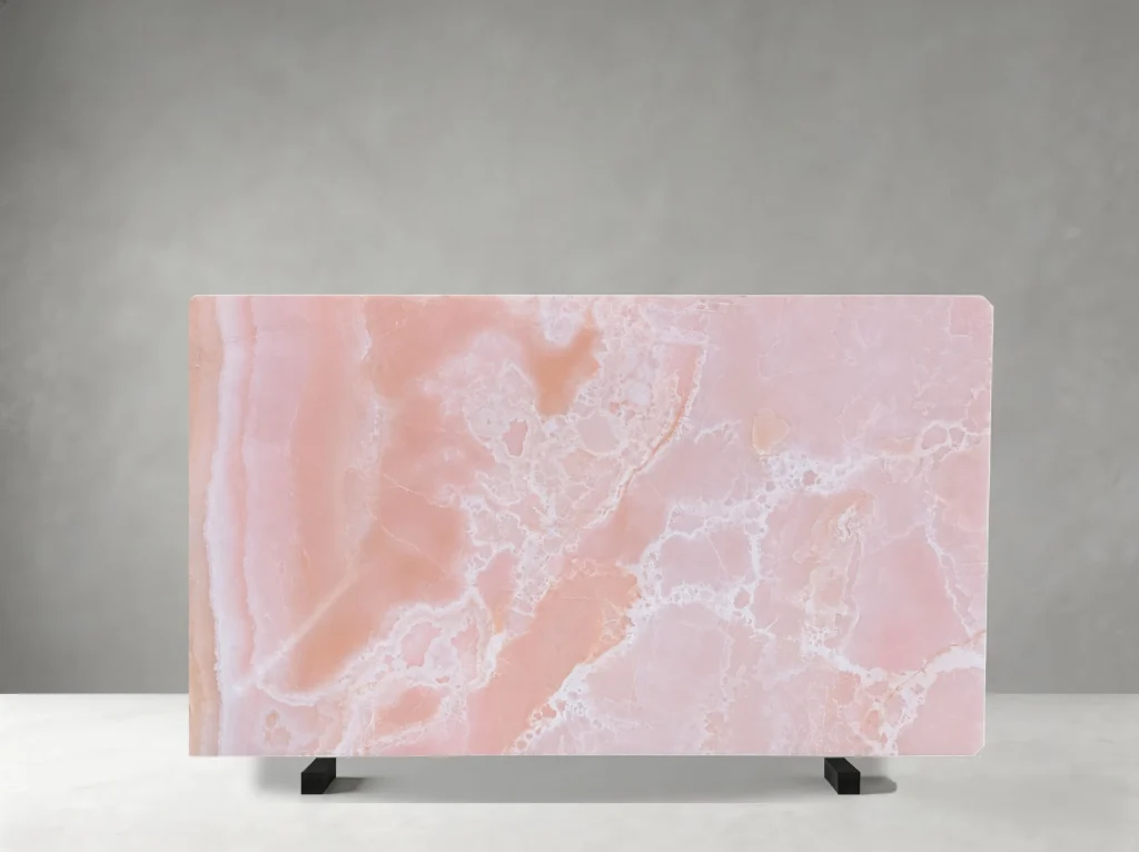 Front view of a polished Pink Onyx slab with blush-pink tones and flowing white crystalline patterns