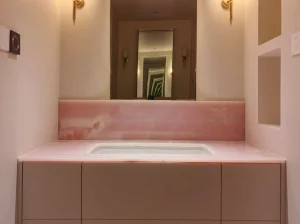 Pink Onyx bathroom vanity top and backsplash with an integrated basin in a luxury residential interior