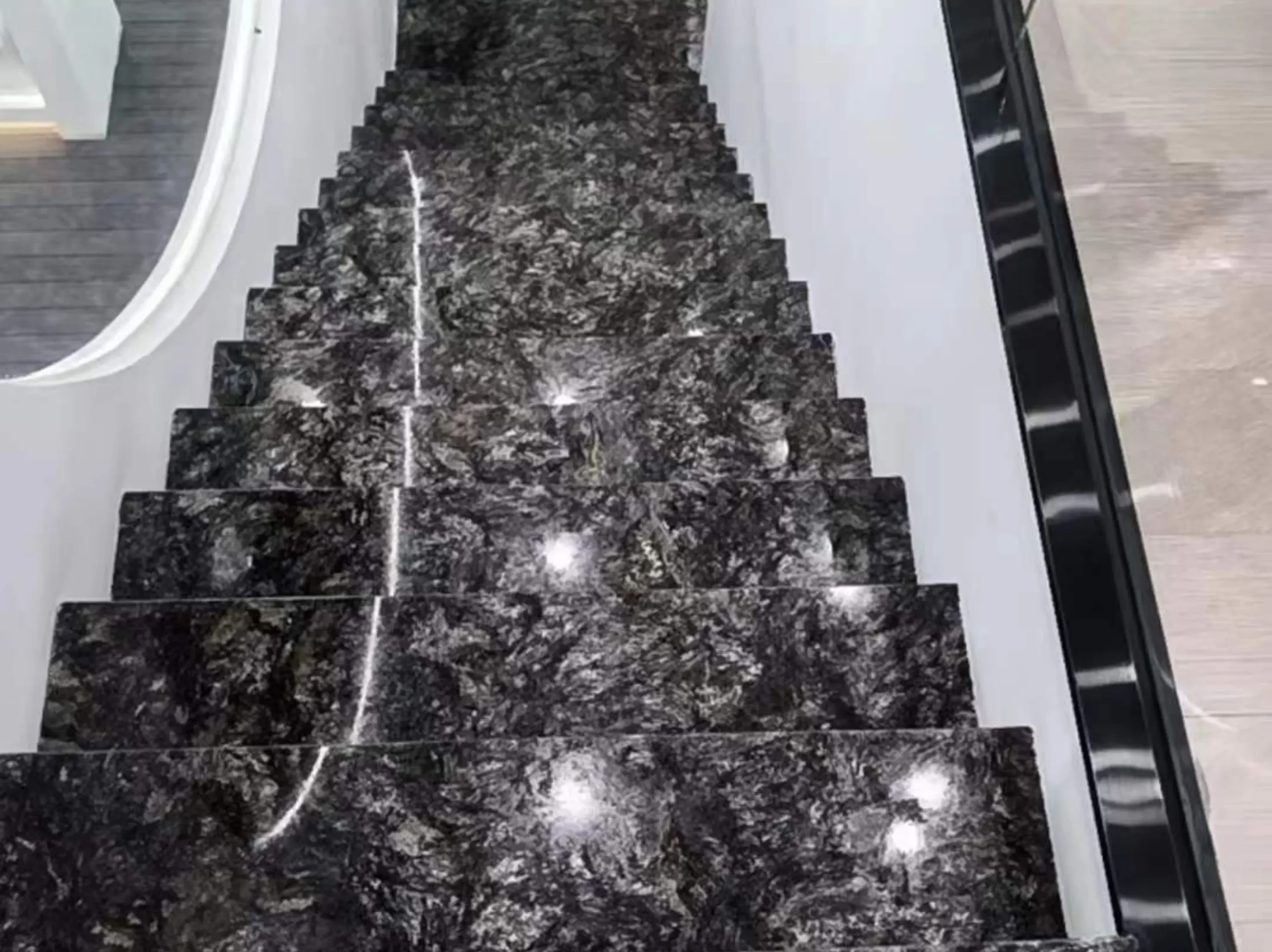 platinum-granite-polished-stair-treads-01.webp platinum granite polished stair treads with dark grey and silver natural mineral pattern