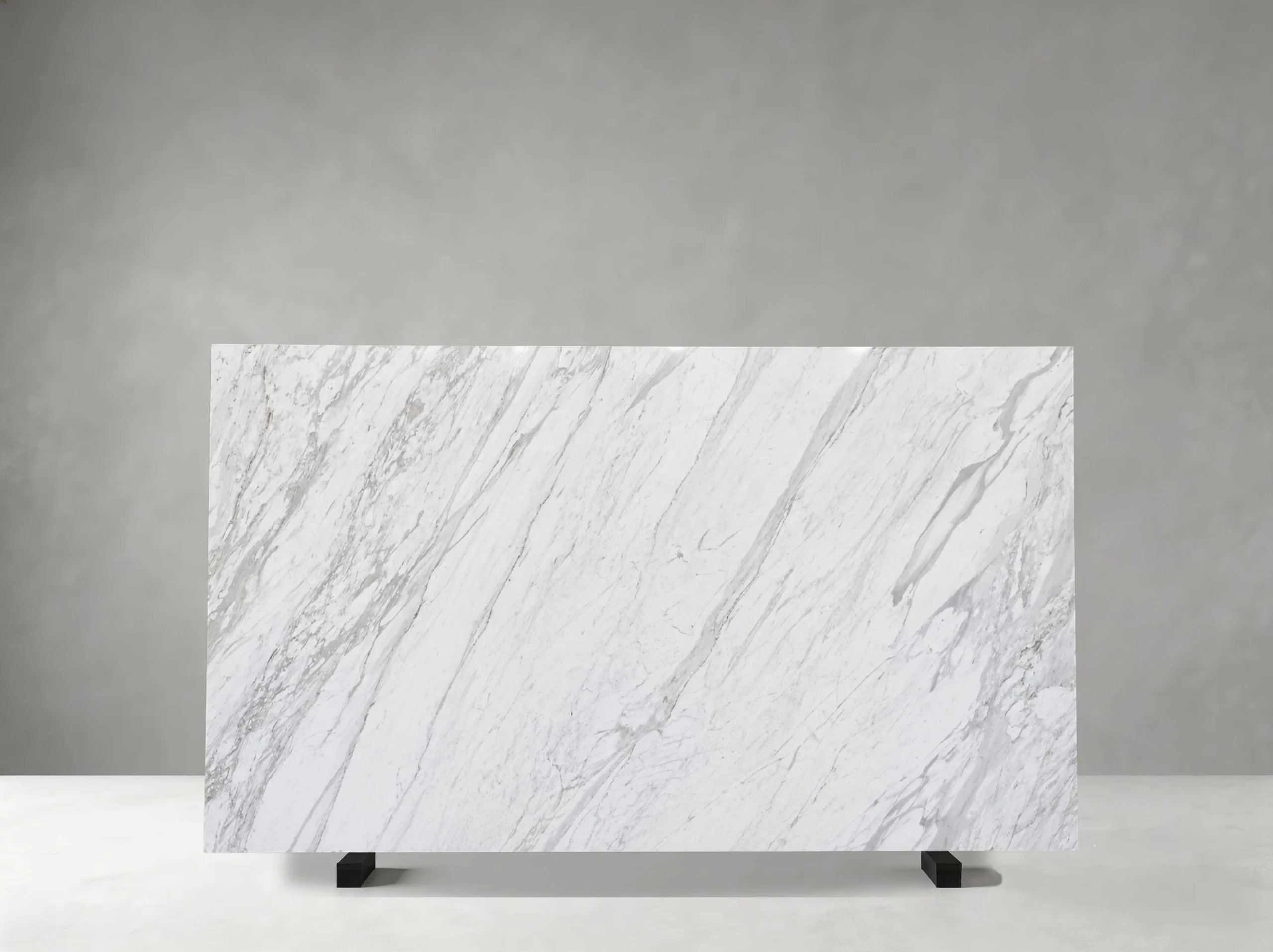 volakas-white-marble-grey-veining-detail.webp Close-up of Volakas White Marble surface with natural grey veining