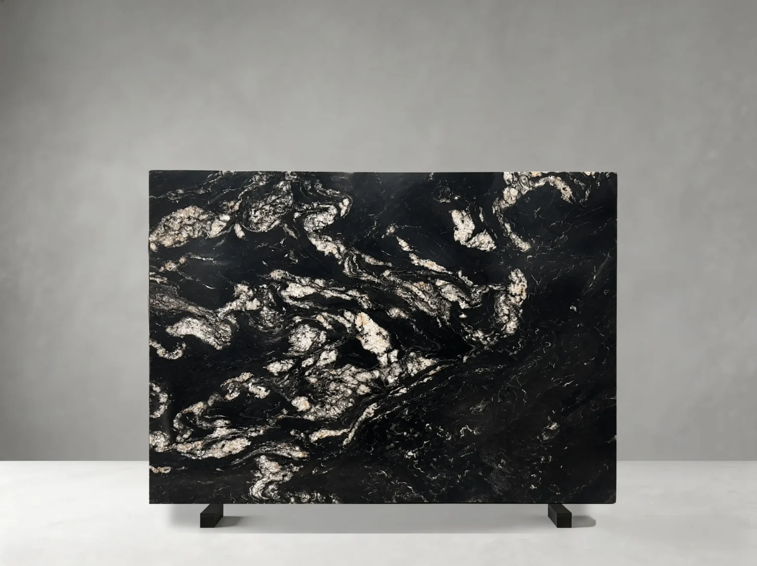 Brazil Titanium Granite full slab showing black, charcoal, silver-white and warm gold tones with large flowing mineral patches and dramatic wave-like crystalline movement